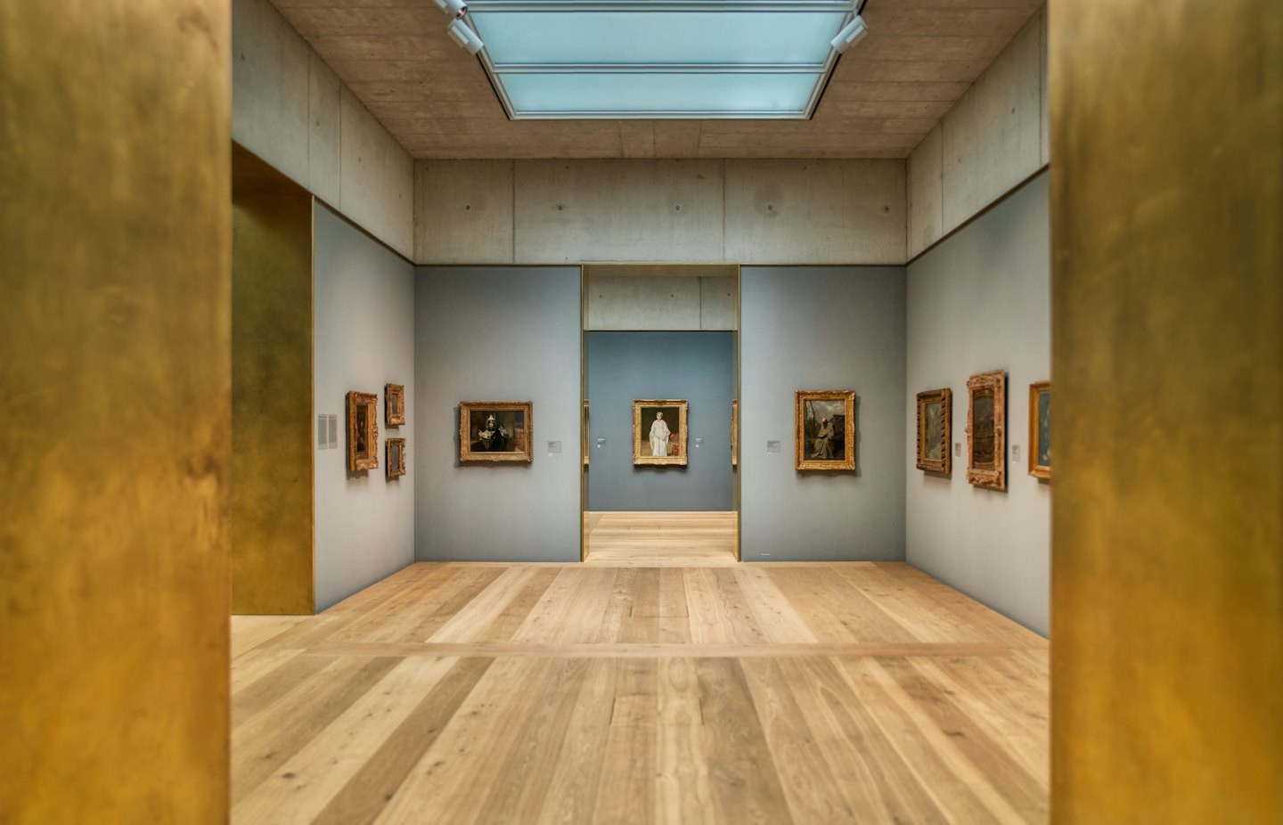 Modern art gallery with oil paintings on grey walls.