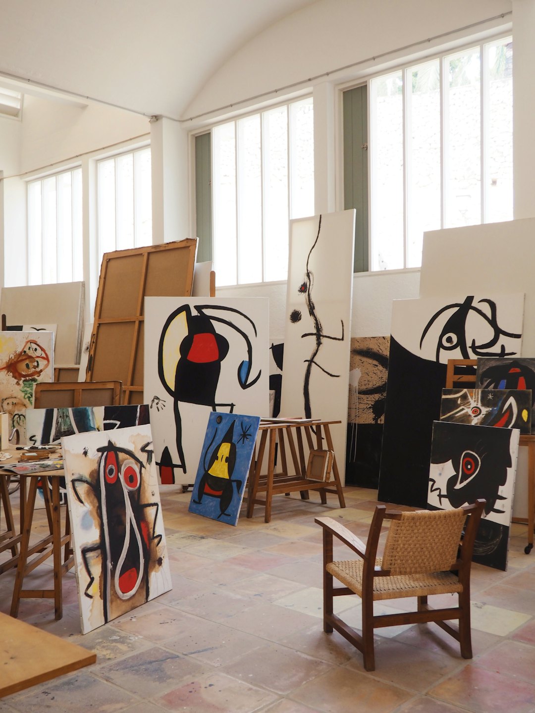 Abstract paintings displayed in a brightly lit artist's studio.